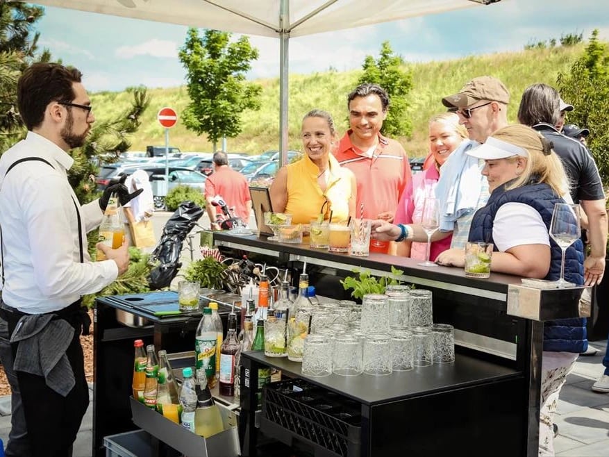 Der Barmann beim Cocktail-Catering im Outdoor-Event mit Gästen