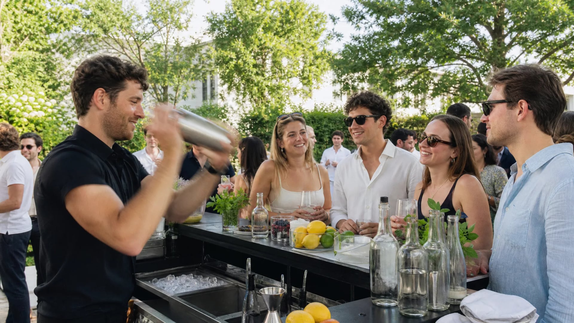 Barkeeper mixt Cocktails an einer mobilen Bar bei einer Sommerfeier, Beispiel für einen Barkeeper