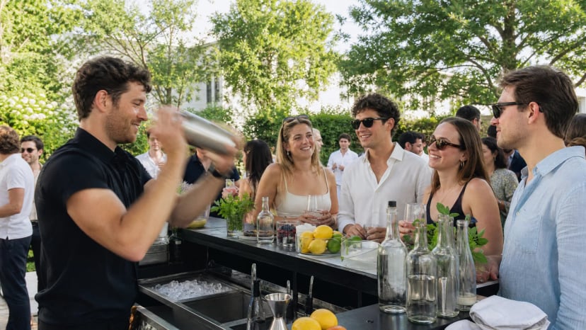 Barkeeper mixt Cocktails an einer mobilen Bar bei einer Sommerfeier, Beispiel für einen Barkeeper