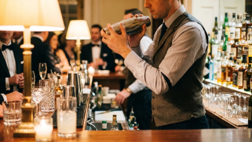 Professioneller Barkeeper mixt einen Cocktail an einer mobilen Theke auf einem Event