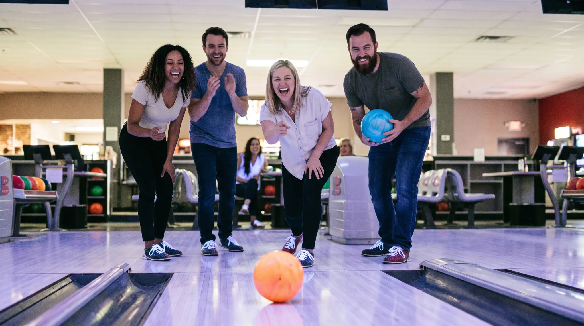 Gruppe feiert gemeinsam beim Bowling in Bonn, eine Spielerin wirft die Kugel