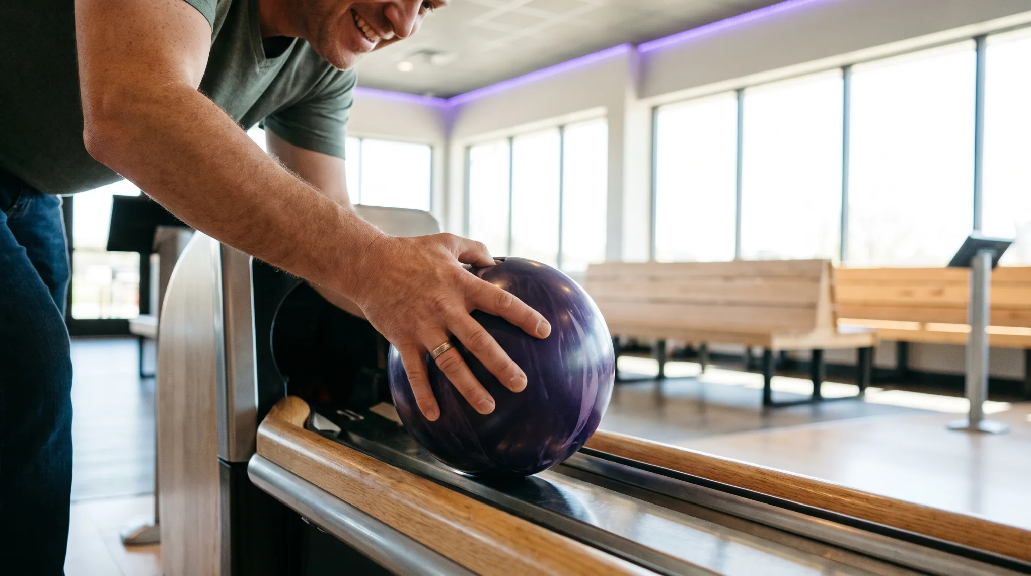 Hand mit Bowlingkugel vor den Pins in einem Bowlingcenter in Köln