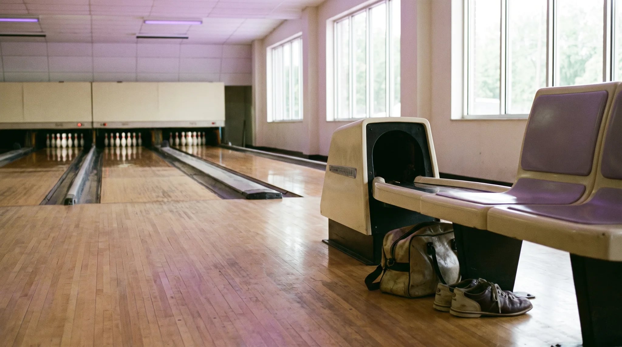 Hand mit marmorierter Bowlingkugel vor den Pins auf der Bowlingbahn in Siegburg