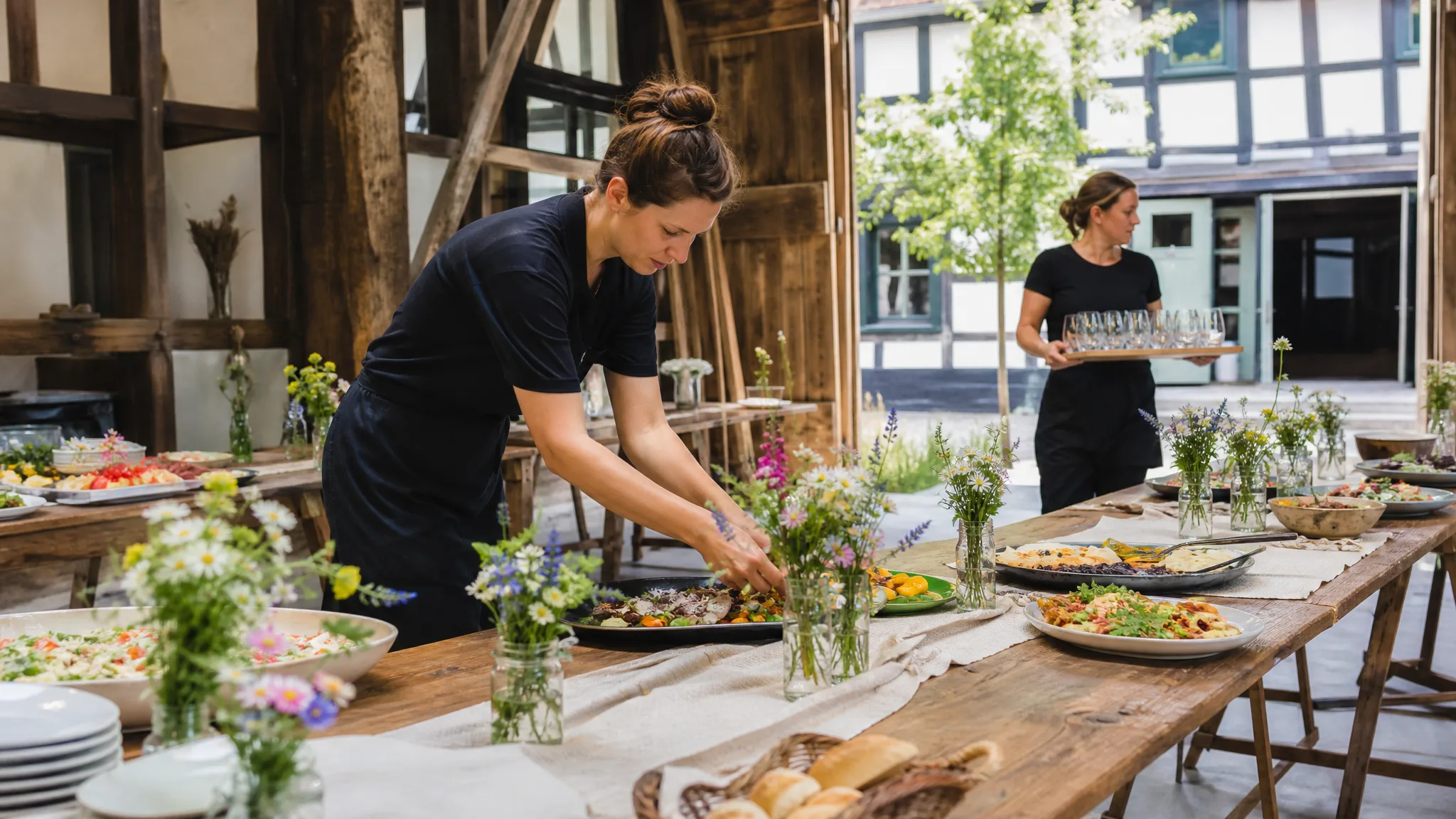 Hochzeits-Catering in Siegburg: Team richtet die Tafel im Fachwerk-Innenhof an