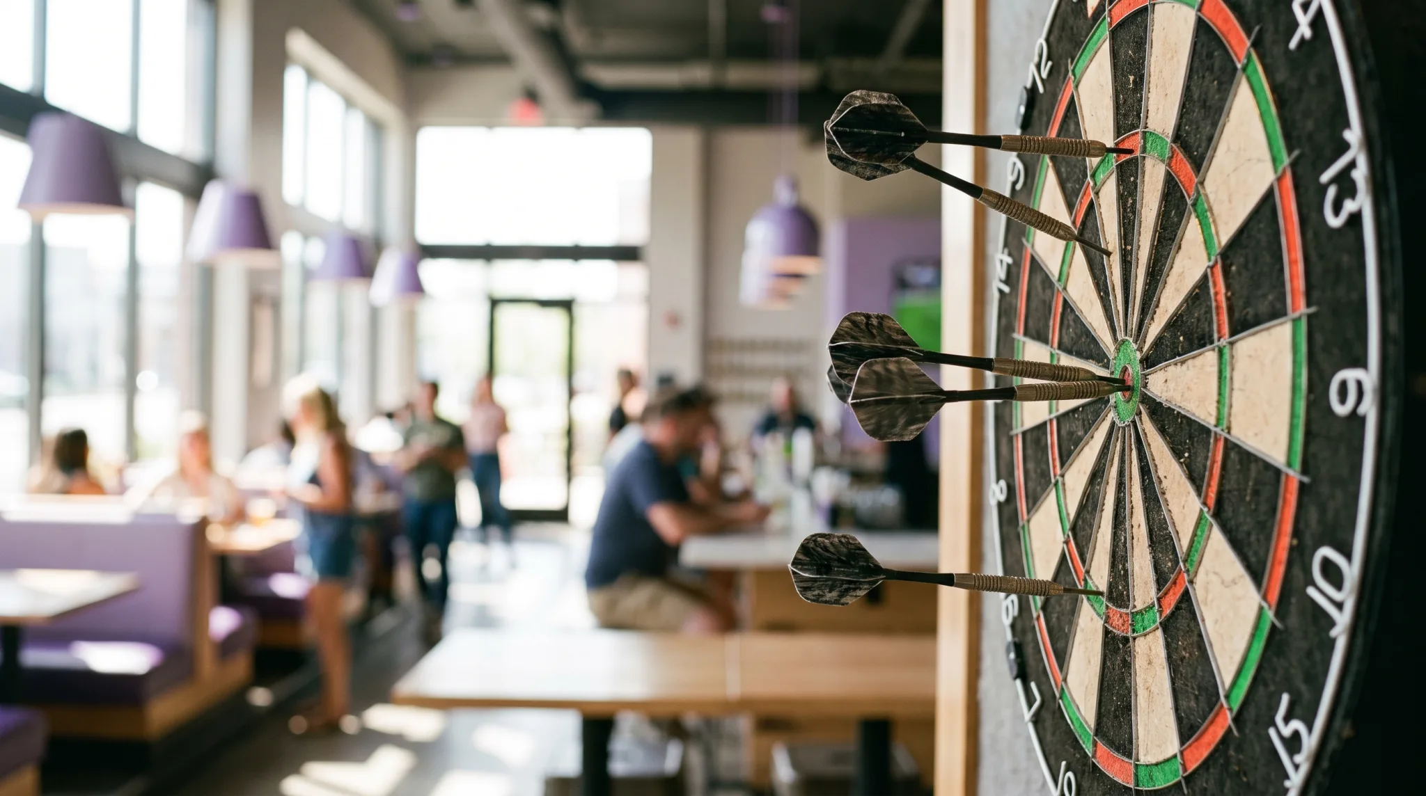 Drei Darts nahe dem Bullseye einer Dartscheibe in Düsseldorf, Hand wirft