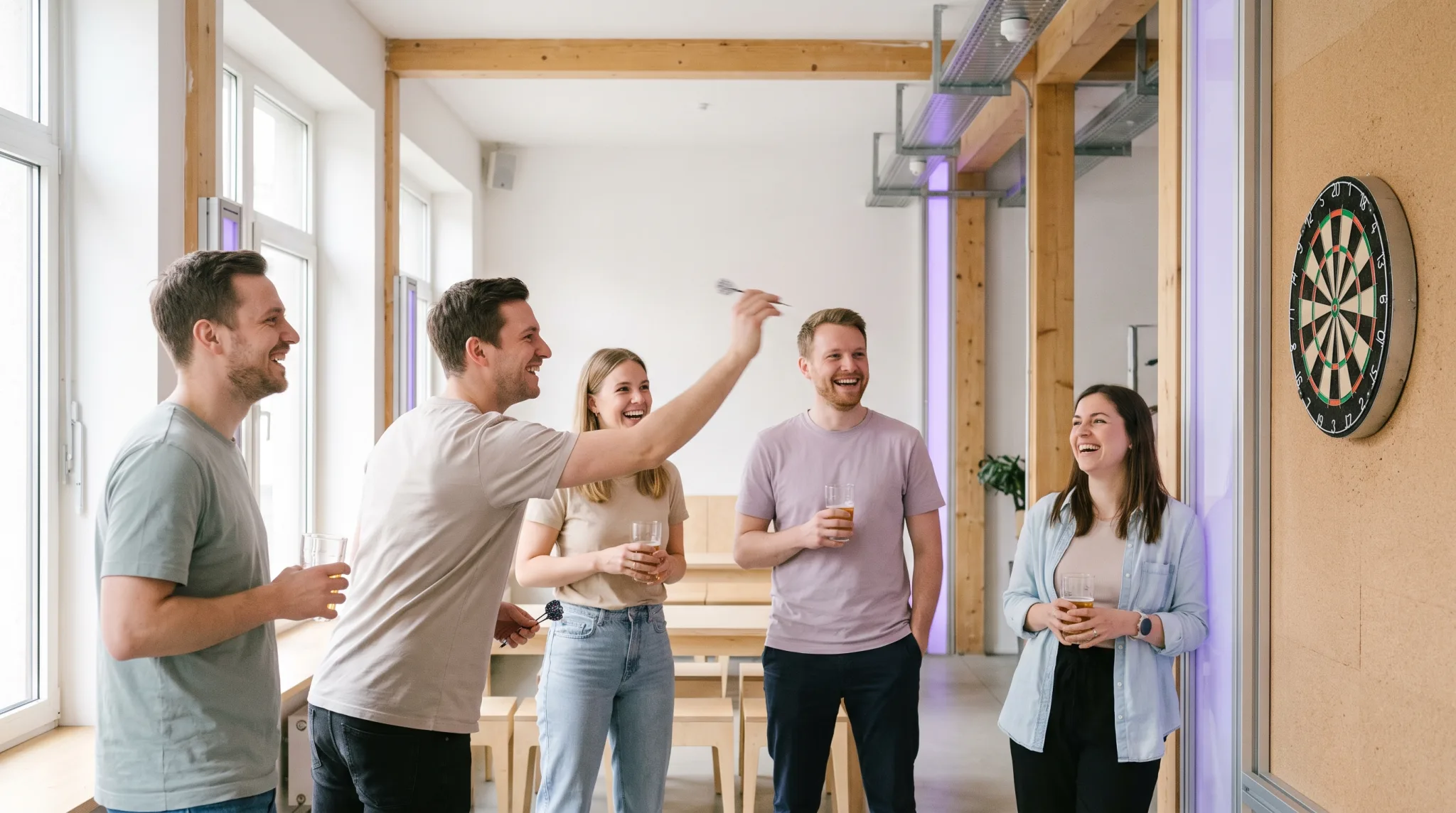 Freundesgruppe spielt Dart in einer Bar in Düsseldorf