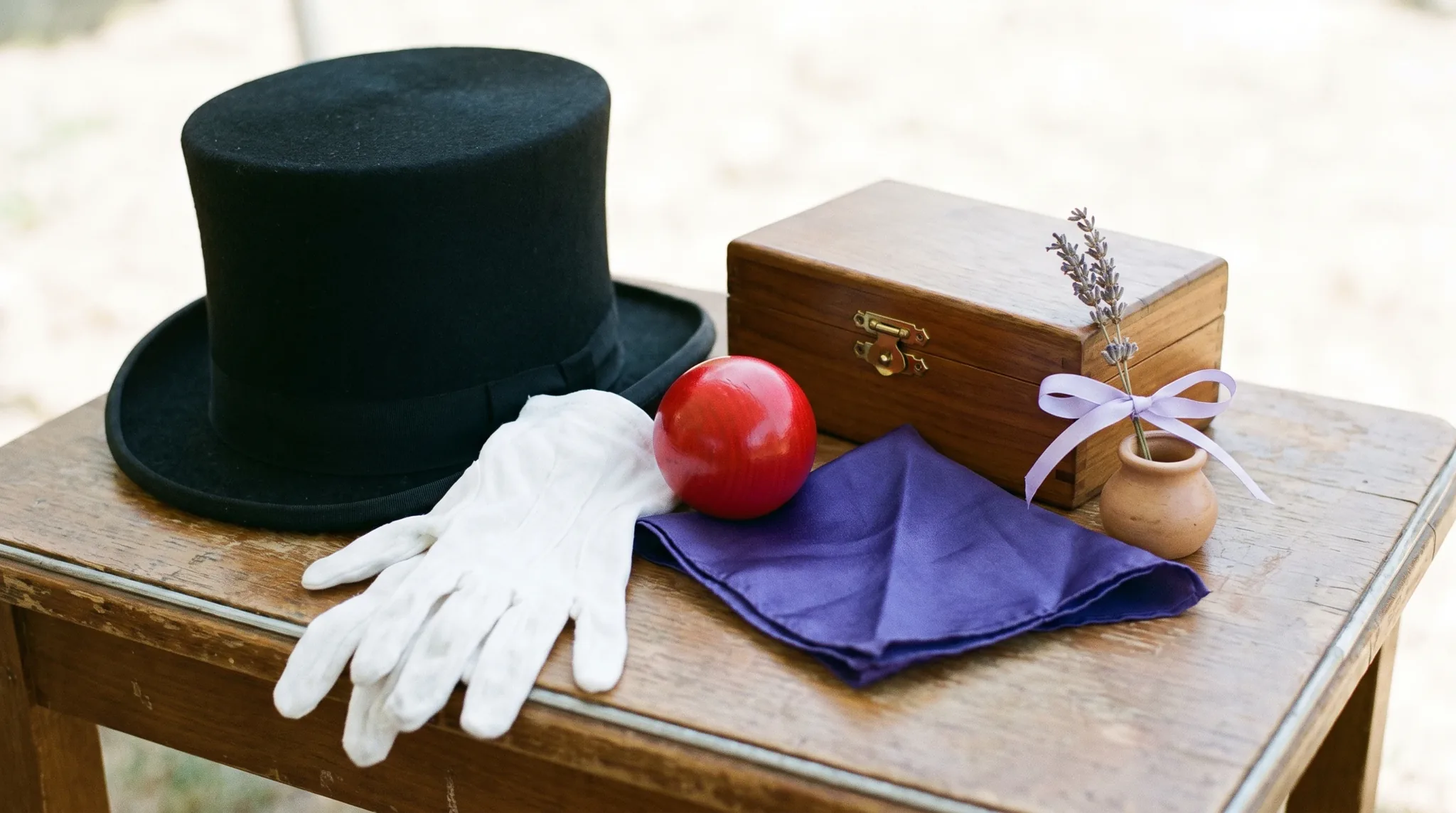 Entertainer in Sankt Augustin: klassische Requisiten wie Zylinder, bunte Seidentücher, Jonglierkeule und aufgefächerte Spielkarten auf dunklem Holz.
