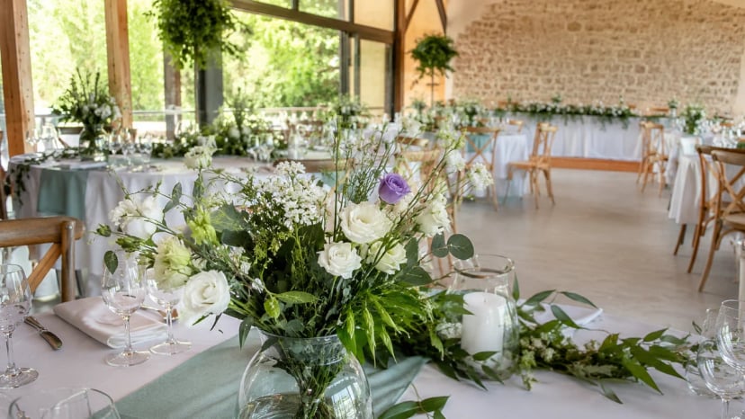 Eingedeckter Tisch mit Blumendekoration in einer modernen Eventlocation Much für Hochzeit und Firmenevent