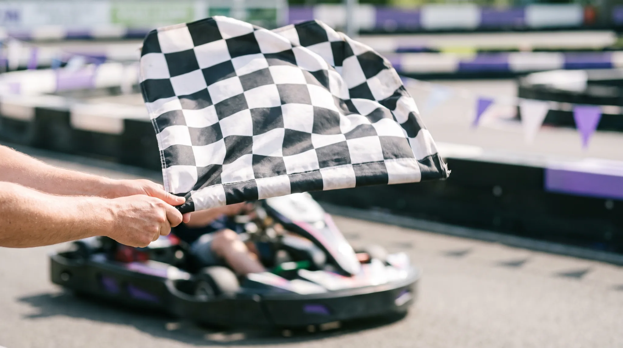 Behandschuhte Hände am Lenkrad eines Gokarts auf der Kartbahn in Siegburg