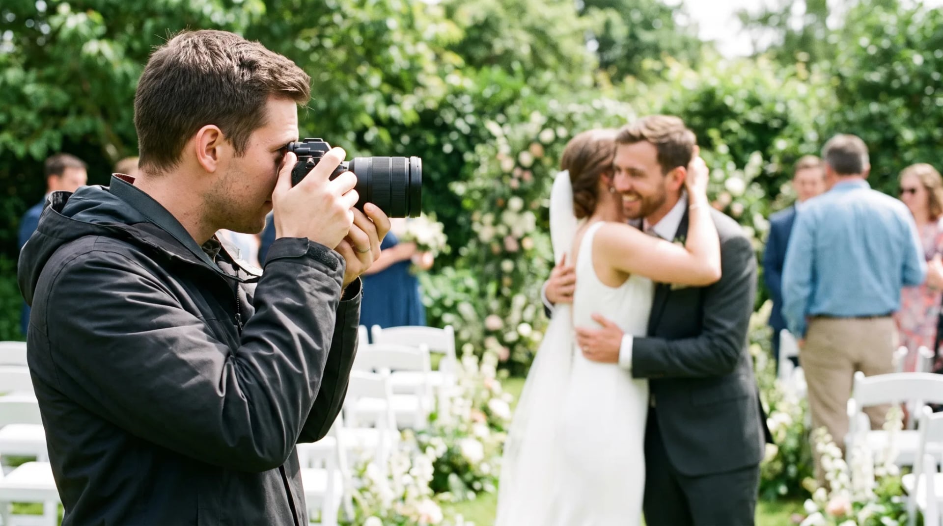 Hochzeitsfotograf fotografiert Brautpaar mit Kamera bei der Hochzeitsfeier