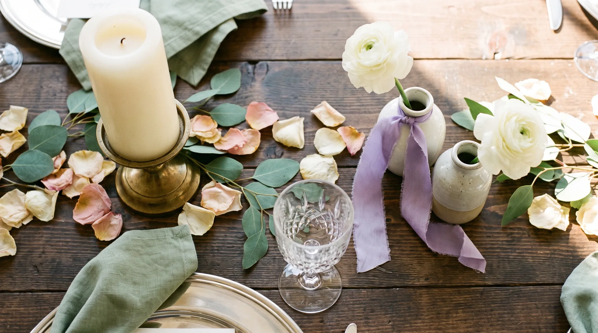 Romantisch gedeckte Hochzeitstafel als Stimmungsbild einer Hochzeitslocation in Engelskirchen mit Pfingstrosenblüten in Elfenbein und Altrosa neben einem.