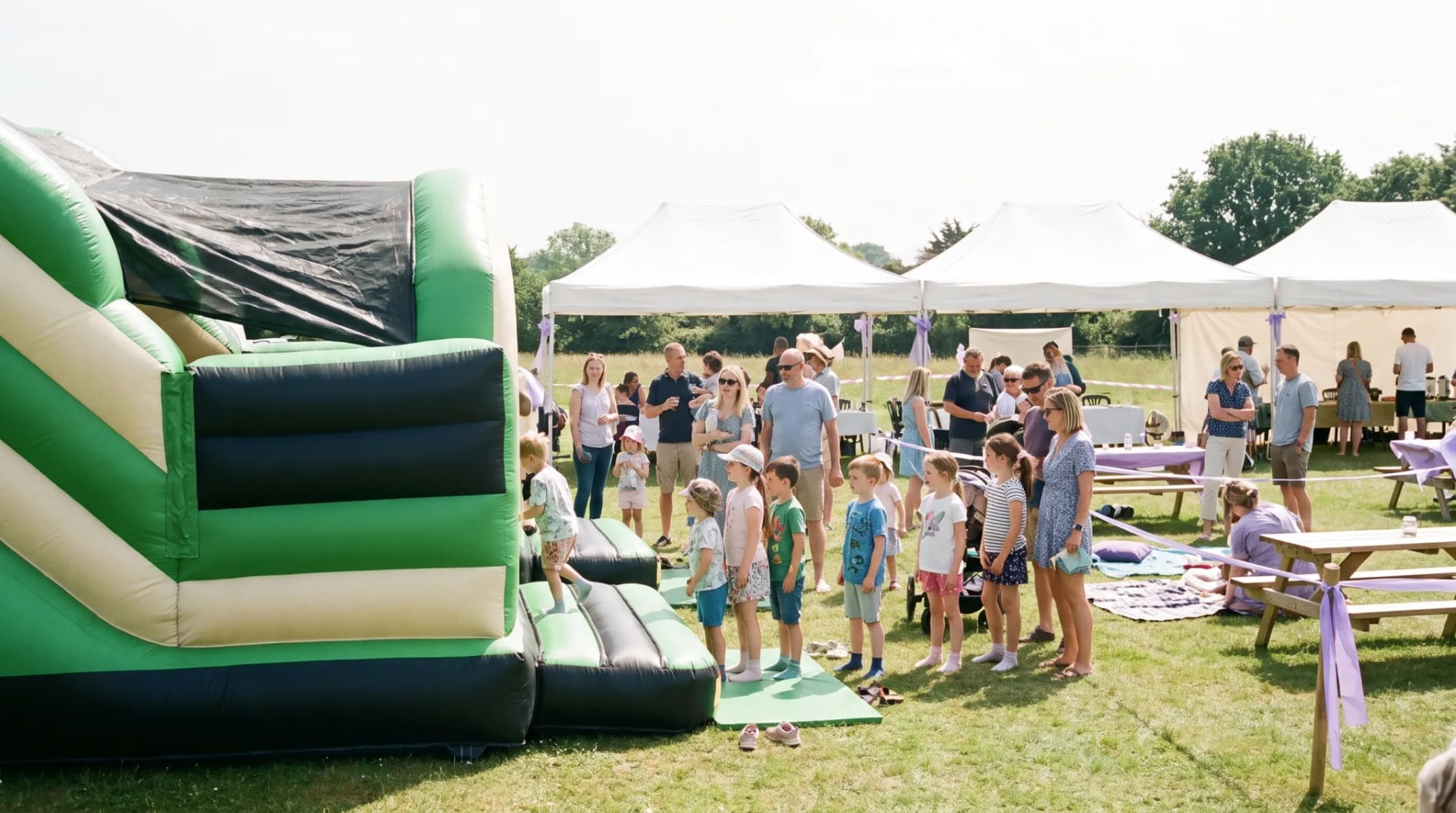 Kinder springen auf einer bunten Hüpfburg bei einem Sommerfest in Bonn