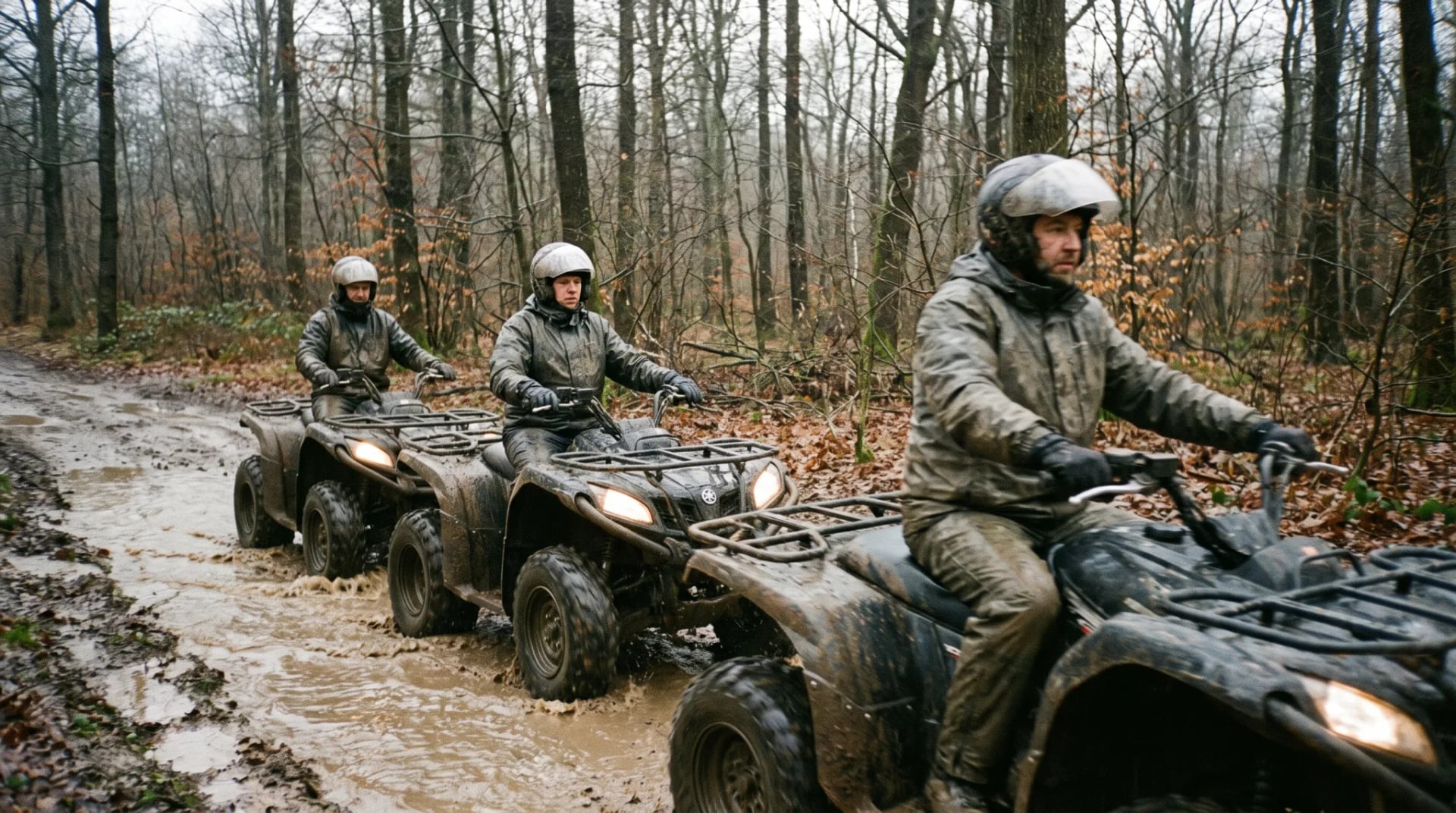 Gruppe auf geführter Quad-Tour fährt über einen matschigen Waldweg