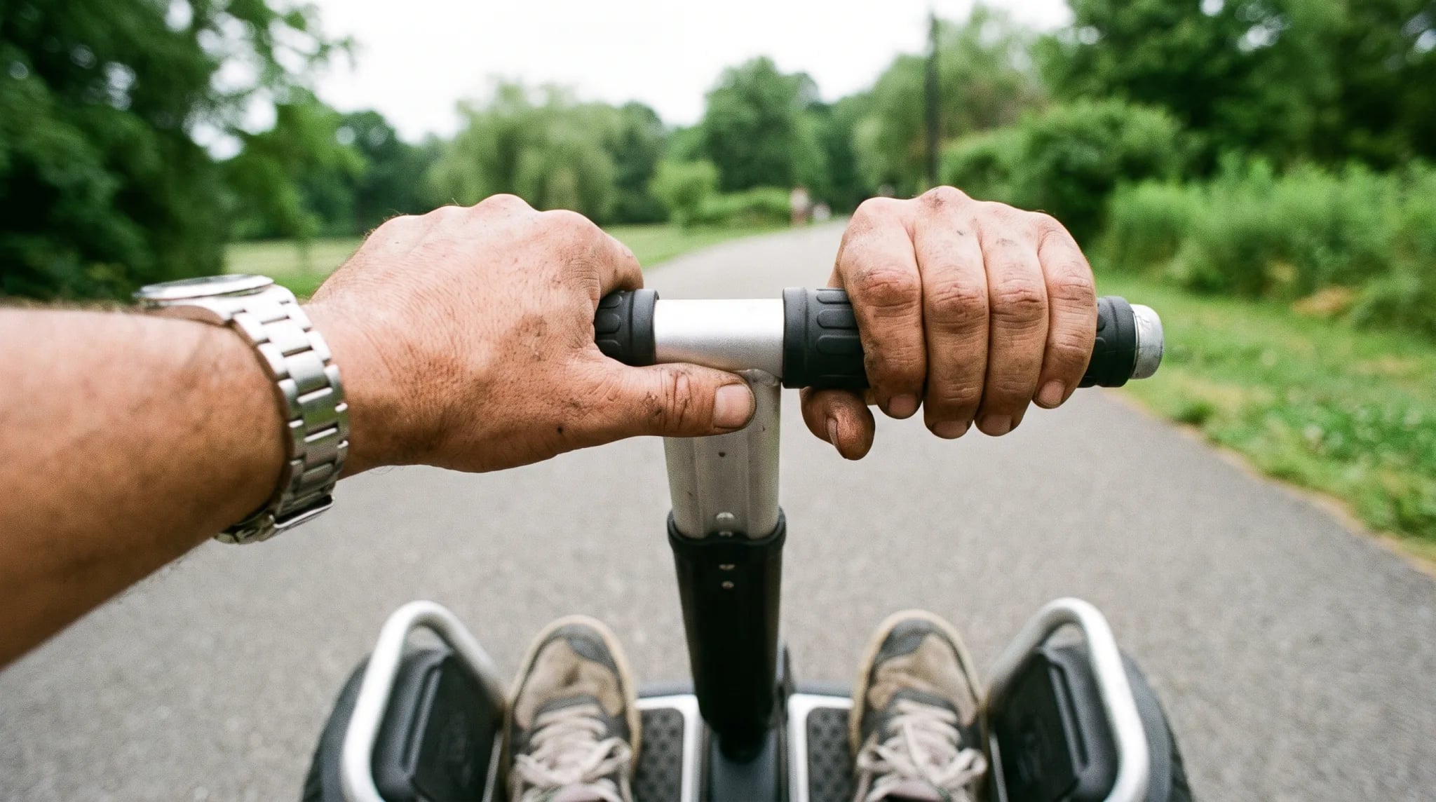 Hände am Lenker eines Segway, Füße auf der Plattform