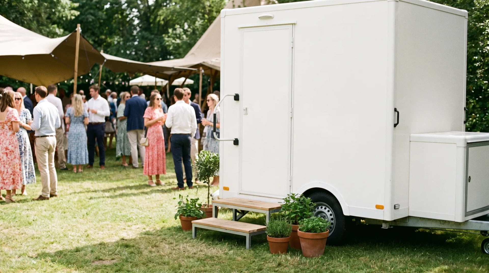 Sauberer moderner Toilettenwagen bei einer Gartenparty im Freien